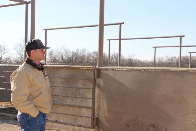 Man looking at corral. 