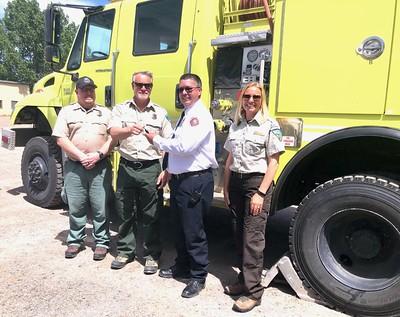 Firefighters in front of a fire engine.