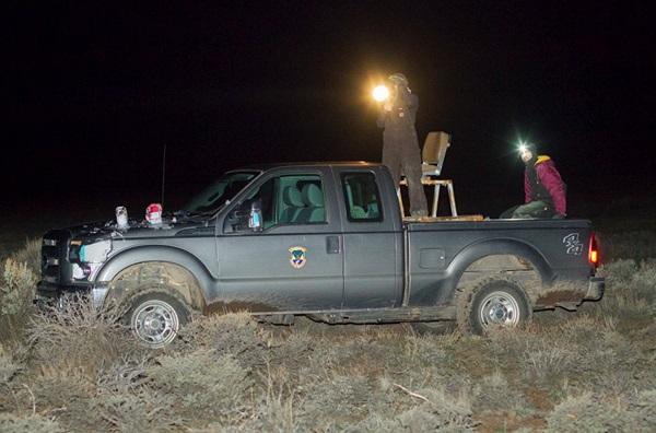 Field crews in a truck with a spotlight