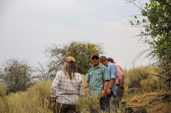 Lonnie looks at the camera in the field with a group of other people. 