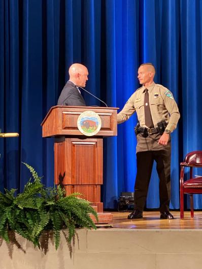 Two individuals stand on a stage