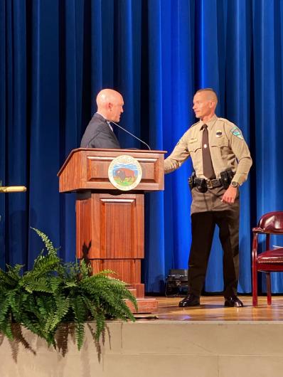 Two individuals stand on a stage