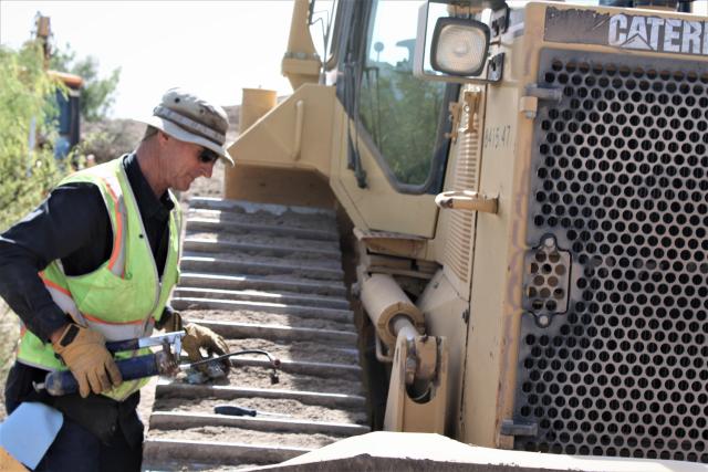 John Strickland, BLM LCDO, heavy equipment operator, performs daily maintenance of the bulldozer prior to operation.