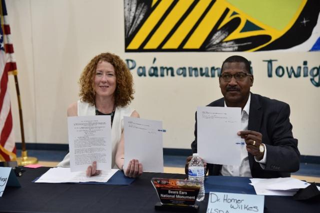BLM Director, Tracy Stone-Manning, and Under Secretary of Agriculture for Natural Resources and Environment, Dr. Homer Wilkes, hold their signed copies of the cooperative agreement.