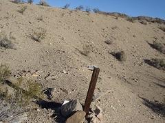 Mining claim marker on a dirt slope.