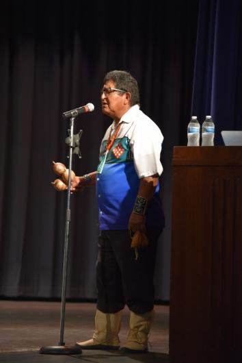 Tribal elder of the Hopi Tribe, Clark Tenakhongva, stands on a stage and preforms original piece at the Artist in Residence concert in Blanding, Utah.