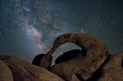 An arched rock with the night sky. 