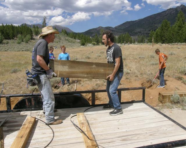 Volunteers carrying a wooden beam