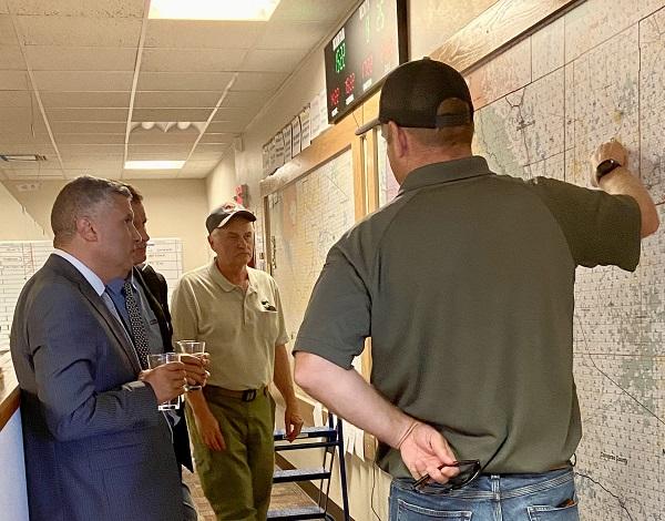 A Wyoming State Forester points to a map describing the land ownership patterns in eastern Wyoming to an audience of three other men. 