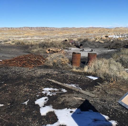 Two rusted barrels with hills in the background