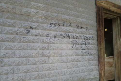 The wall of an old building including writing and shipping information from the early 1900s.