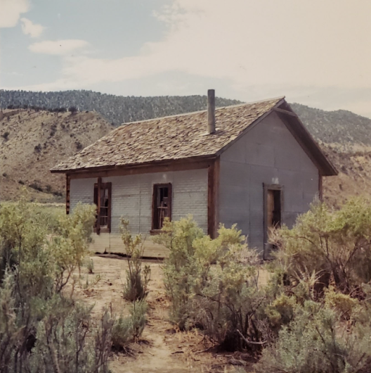 A small rectangular building in a field.