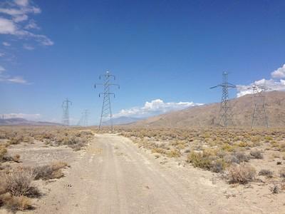 Road in the desert with power lines. 
