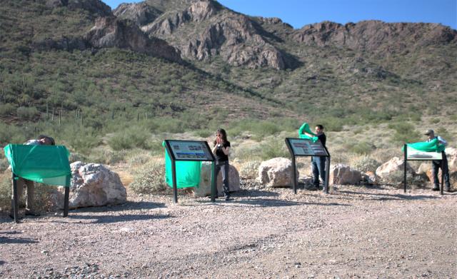 4 interpretive panels being unveiled by 4 people. Mountains standing in the background.