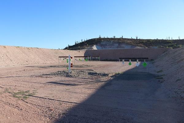 Recreational shooting site with red, green, and white targets of different sizes in a brown pit. 