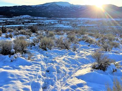 Snow on the ground with mountains in the background. 