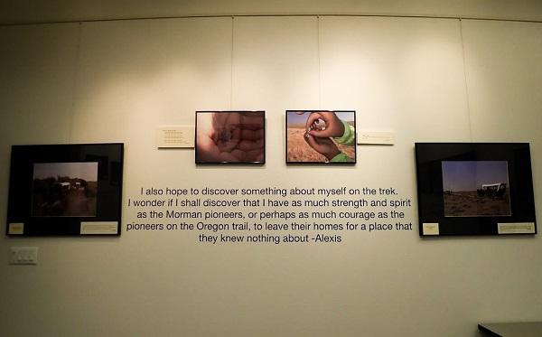 wagon trek and student-curated exhibit: Four photos and a quote from one of the children are on the wall. 