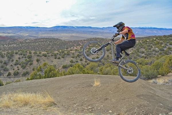 A mountain bike rider with his wheels in the air on the new trail 