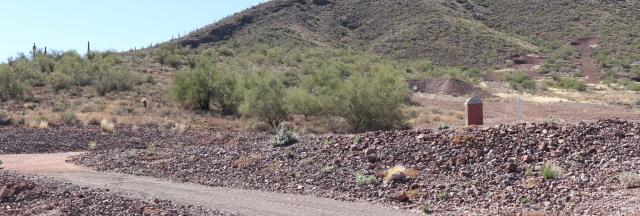 a desert landscape with distant targets and earthen berms