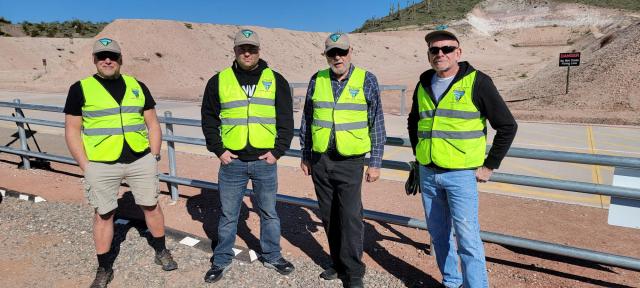 four men wearing bright yellow vests