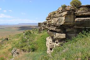 A rock formation stands on the right overlooking the plains.