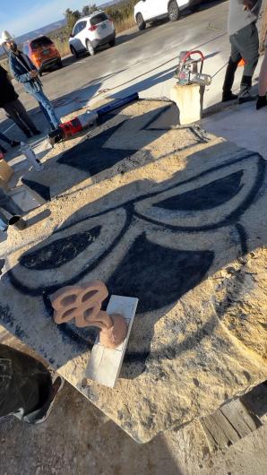 The Tribo Electricity scaled-down version sits on top of the massive chunk of limestone that has black markings on it.