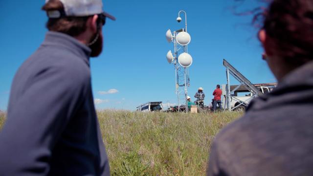 Employees in the field setting up a remote fire camera system.