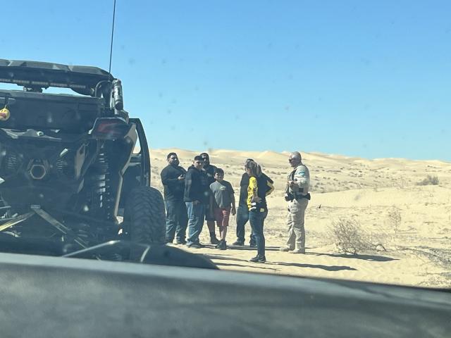 Officer assists stranded motorists in the desert.