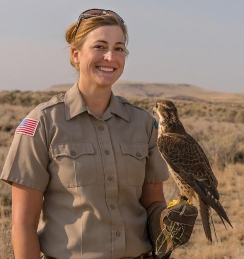 A woman holds a raptor. 