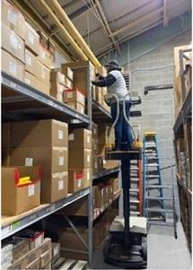 worker placing boxes on a shelf in a warehouse