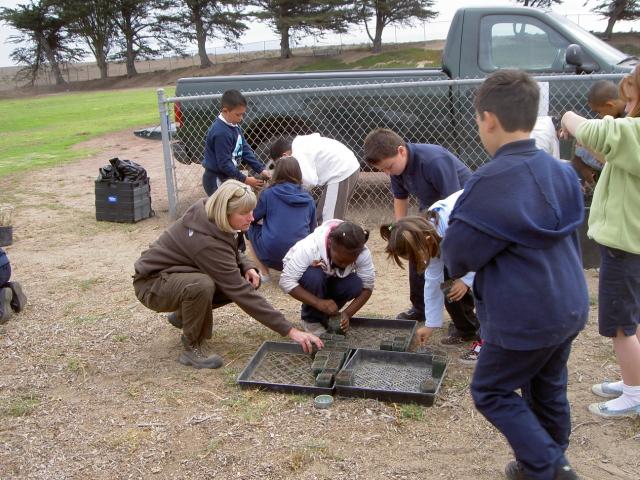 Sowing native seeds at Olson Elementary school. Students learn all about the restoration process at Fort Ord. 