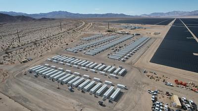 Solar batteries in the desert with mountains in the back ground.