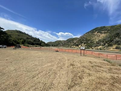 A freshly grated road between two hills.