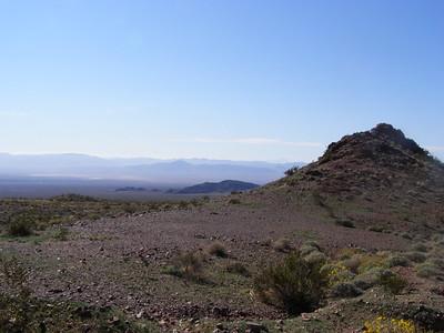 A desert mountain overlooking a valley floor.