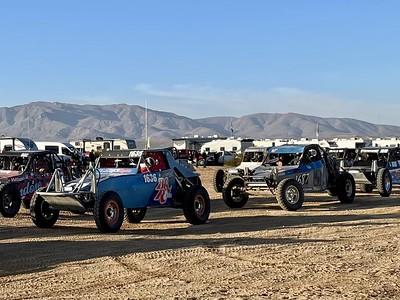 A line of off road racers line up in the desert.