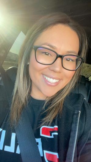 A woman wearing glasses with a seatbelt on.