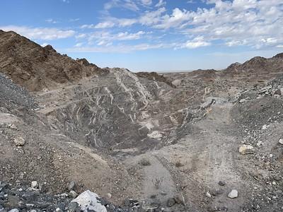 An open mine in the desert comprised of black and white striped stone.