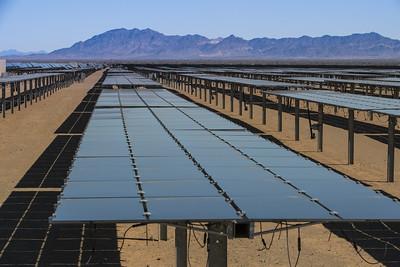 solar array in the desert with mountains in the background. 