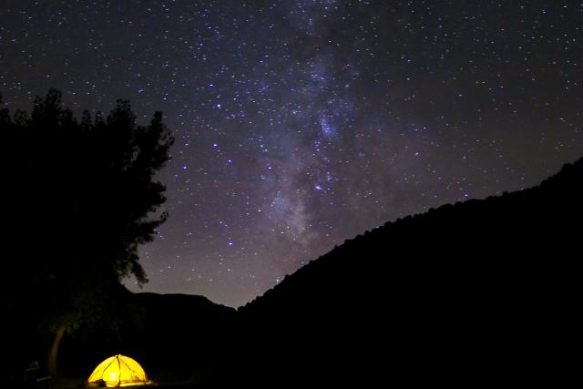 A yellow tent under dark skies in the Rio Grande Del Norte National Monument. 