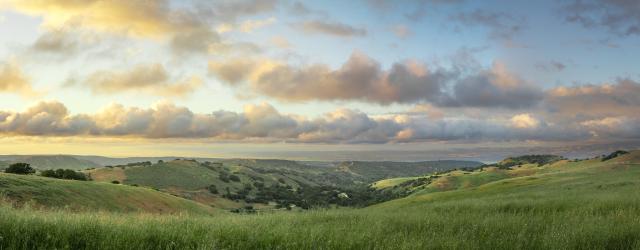 Sunset over rolling, green hills