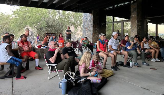 Attendees watch a Scary Desert Creatures presentation in an outdoor pavilion 