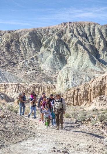 A ranger leads children on an interpretive hike through the desert. 