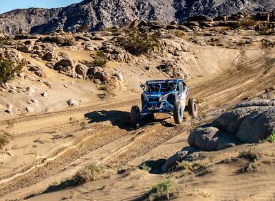 A off road, rock crawler careens down a desert road.