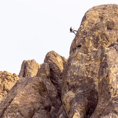 climber going up a steep rock