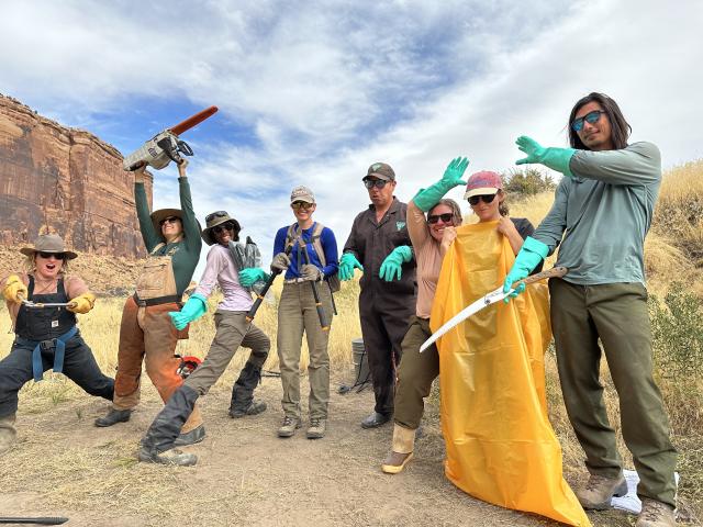 The team highlights tools they use to accomplish the tamarisk removal while keeping themselves and their co-workers safe. Their gloved hands hold chainsaws and folding saws.