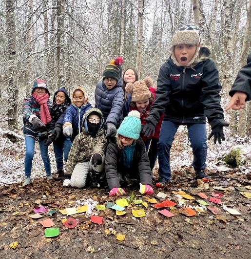 A group of students show off the different colors they found in nature using paint samples. 