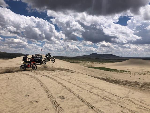 Motorcycles catching air in the Killpecker Sand Dunes Open Play Area