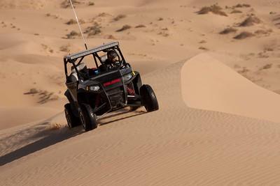 An OHV ascends a dune.
