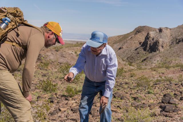 Elderly rounhounder shows a cool find to a fellow hiker in Afton Canyon in California's Mojave Trail National Monument.