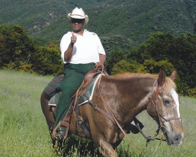 Gloria Brown, former BLM leader, on a horse doing trail duty for work.